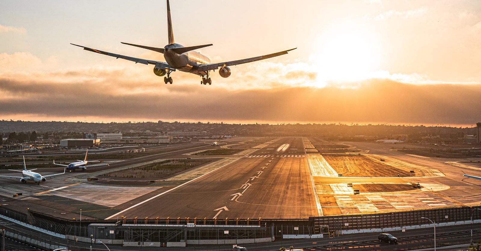 How to Avoid Back Pain While Traveling: A Chiropractor's Guide -pipe Sports Chiropractor San Diego Airplane landing at San Diego International Airport at sunset, seen from above the runway